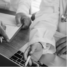 Close up of a healthcare professional pointing with a pen in hand.